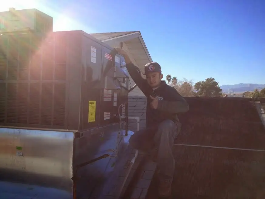 HVAC technician performing AC Tune-Up on a rooftop unit in Winder